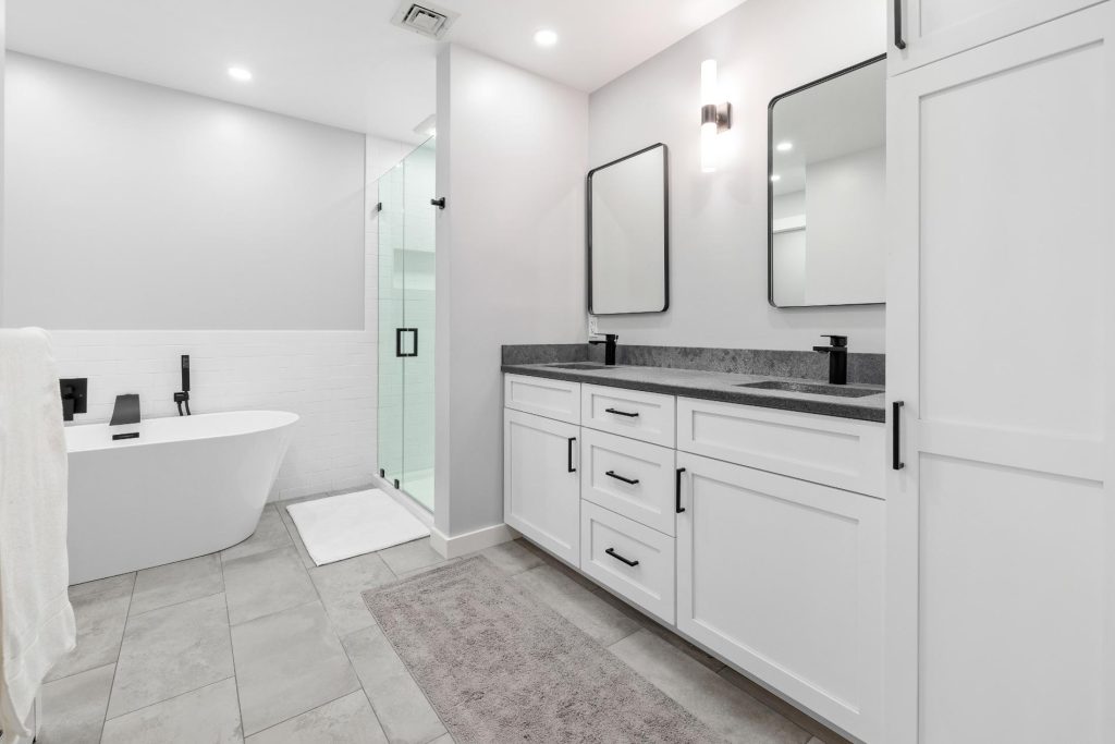 Black quartz bathroom vanity installation in Bow, NH remodel with white cabinetry
