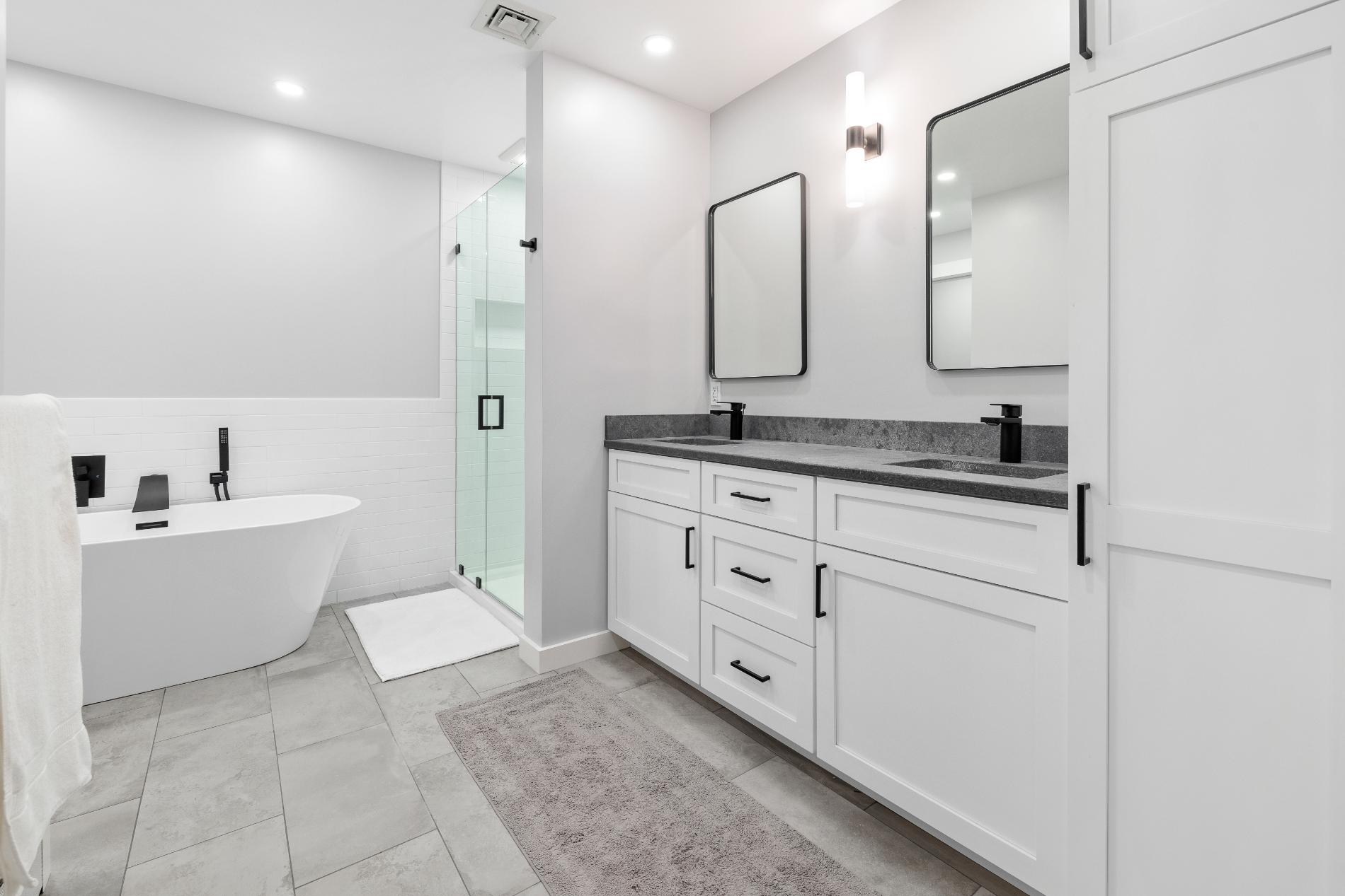Black quartz bathroom vanity installation in Bow, NH remodel with white cabinetry