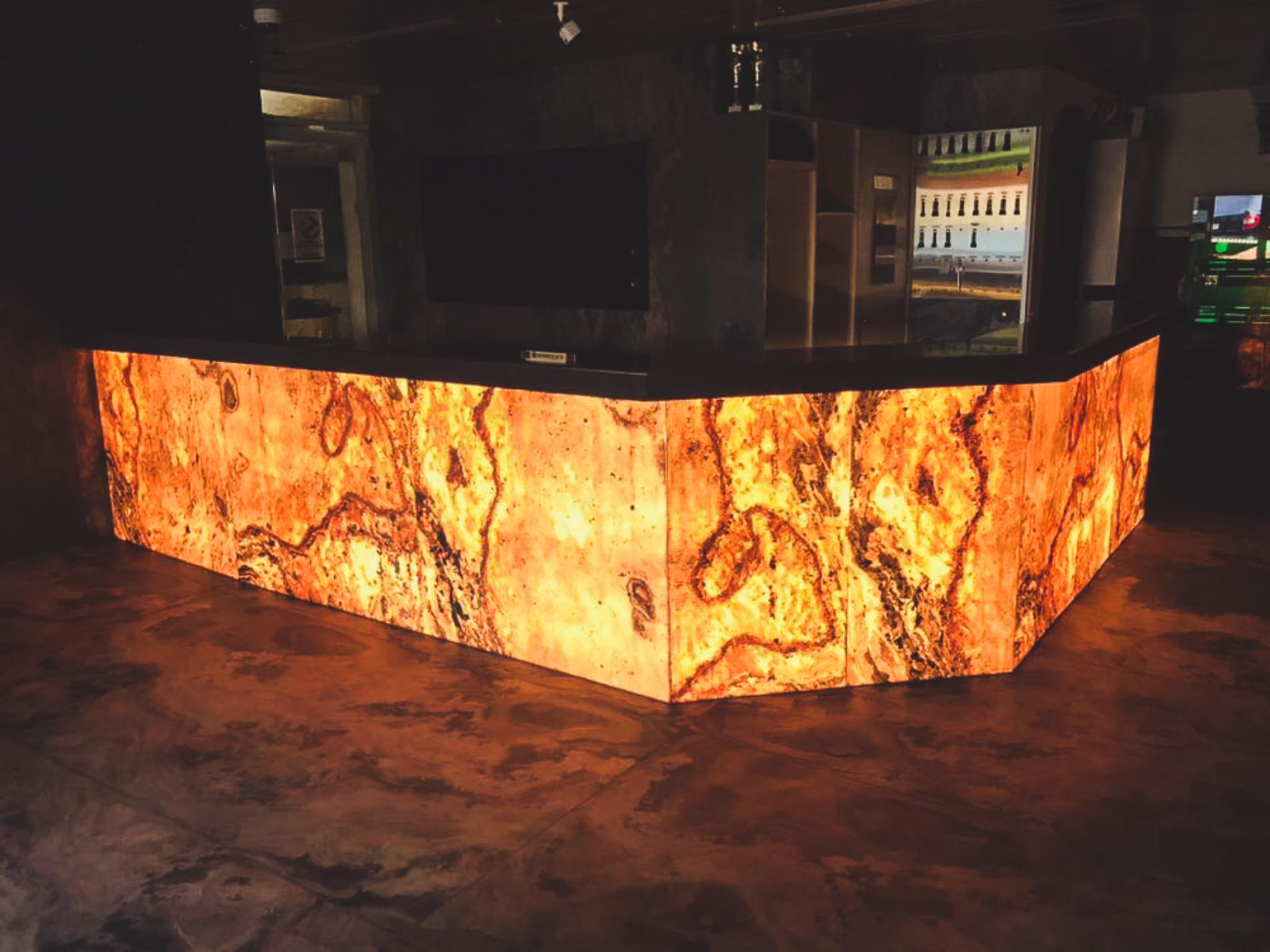 Yellow orange translucent bar counter with backlit quartz surface